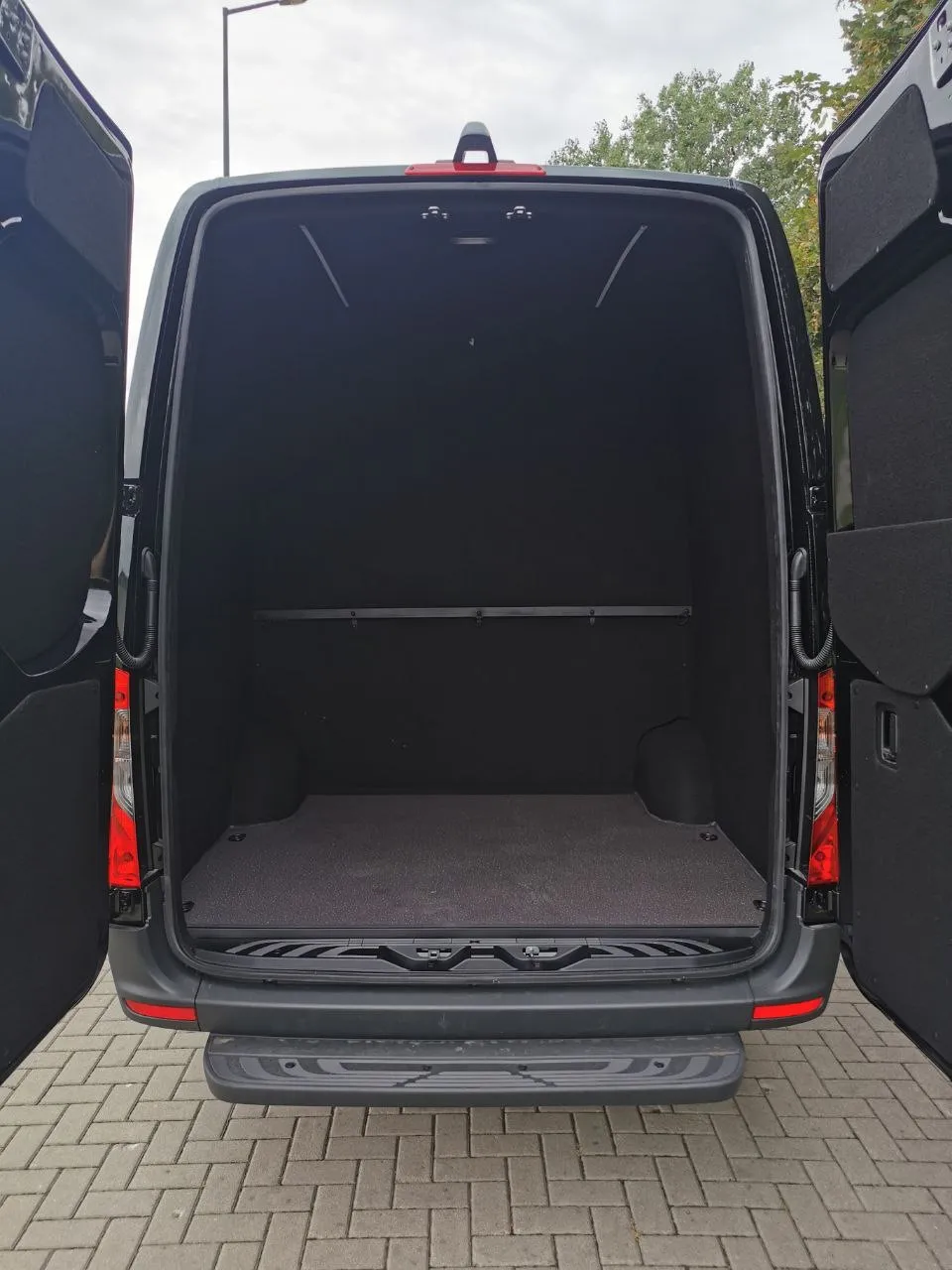 Otwarta przestrzeń ładunkowa busa Mercedes Sprinter widziana od tyłu